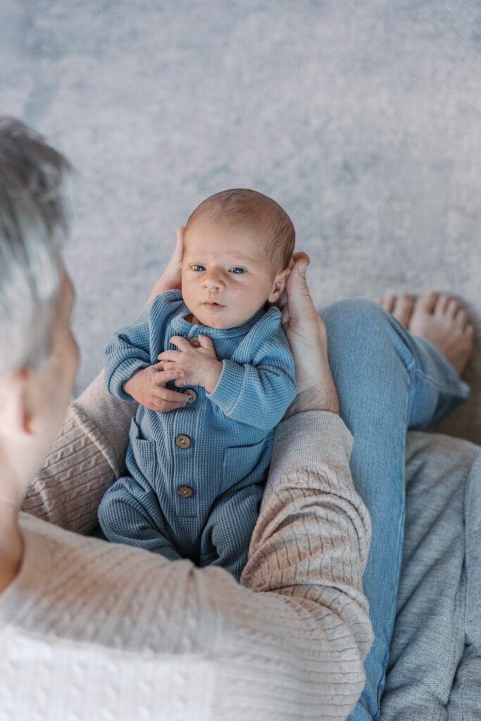 Dad gazing at newborn during a relaxed in-home newborn photography session in the Bay Area