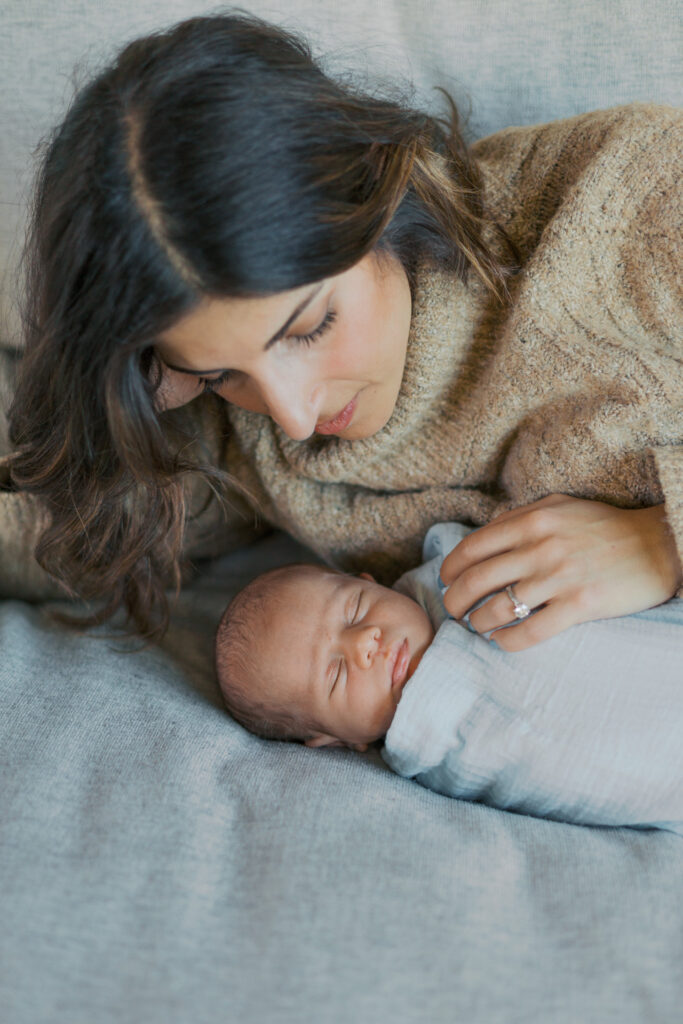 Mother holding her newborn baby during an in-home photography session in Alameda