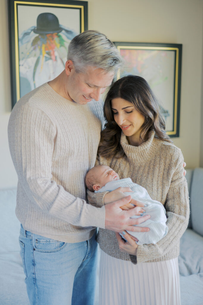 Parents cuddling their newborn during a relaxed in-home newborn photography session in the Bay Area