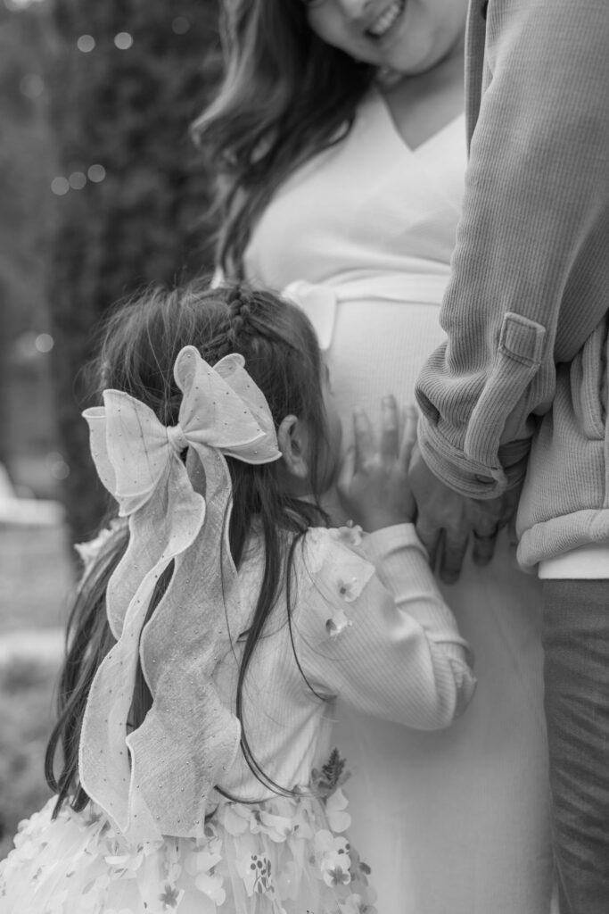 toddler kisses moms pregnant belly at maternity photography session at Filoli in Woodside