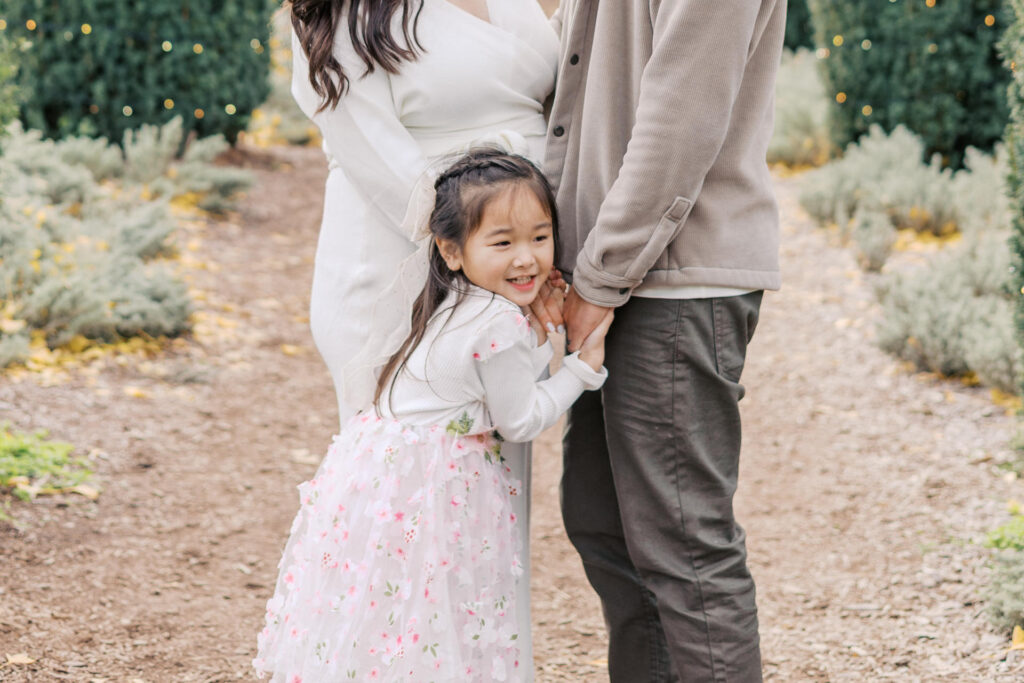 toddler holds mom and dads hands during bay area maternity session