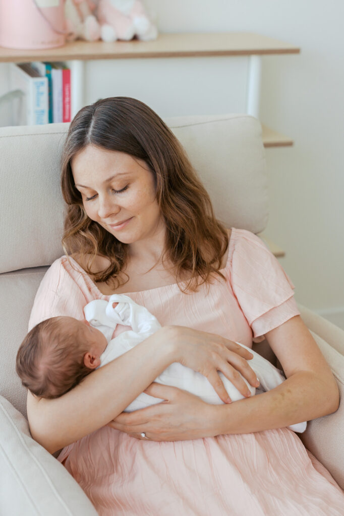 new mother holds newborn baby during her in home newborn photography session in San Francisco