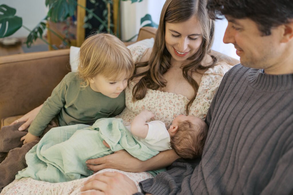 Family of four gazes at newborn during San Francisco Bay Area newborn photography session