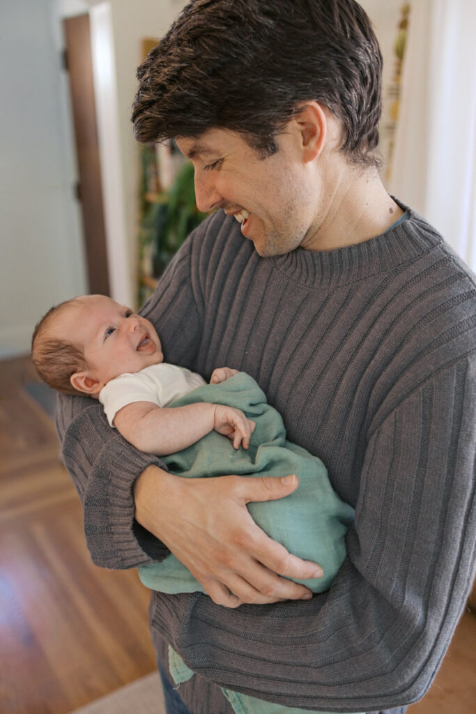 newborn baby smiles at dad