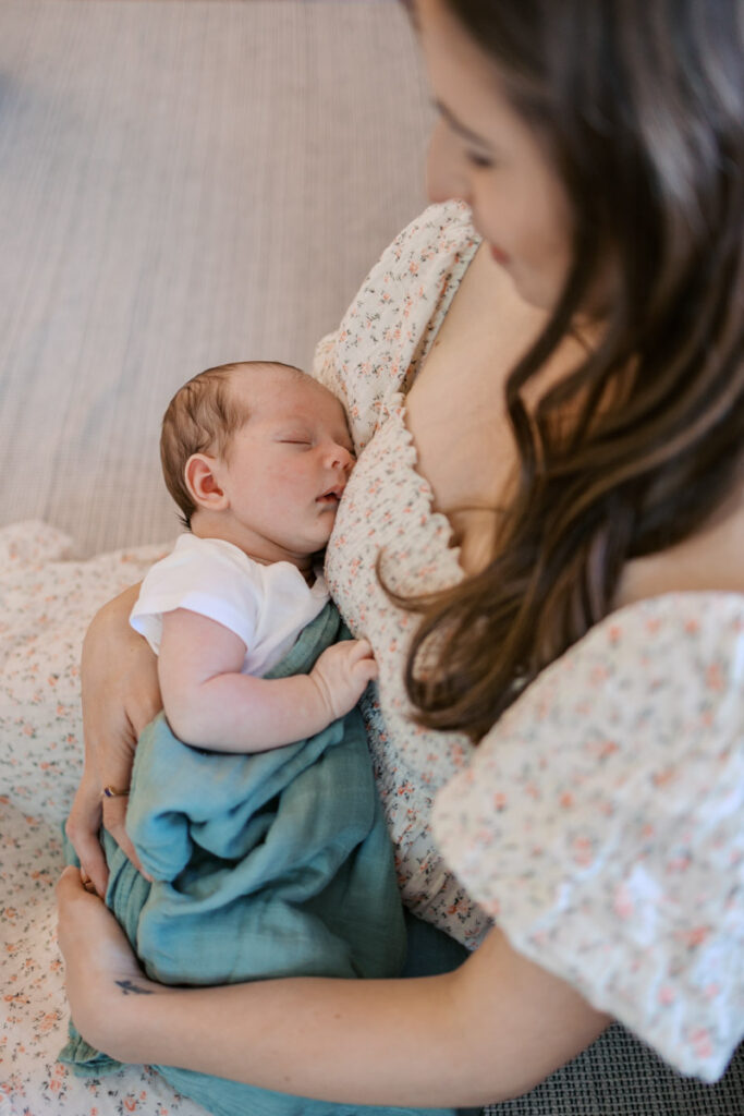mom holds sleeping newborn during newborn photography session
