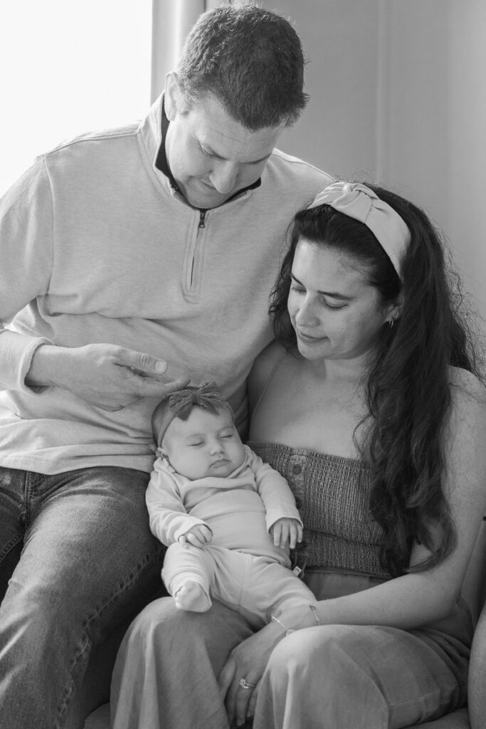 mom and dad gaze down at sleeping 2 month old during newborn session in bay area