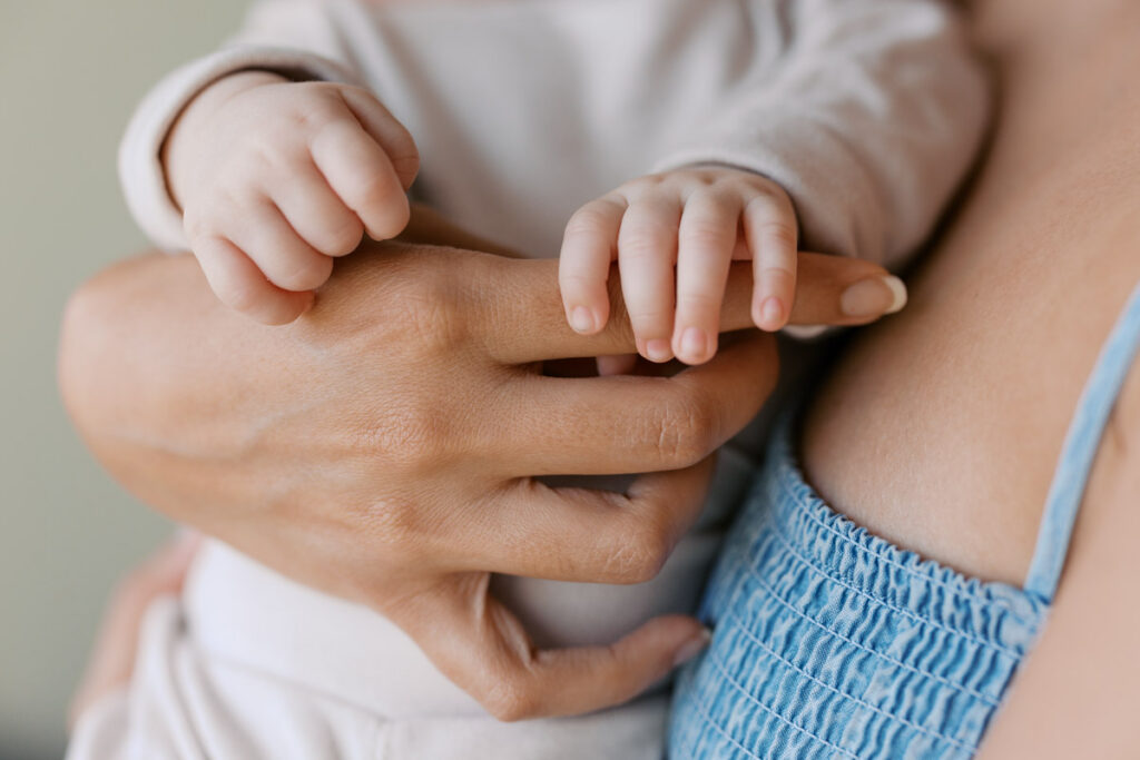 baby fingers next to moms fingers during newborn photography session