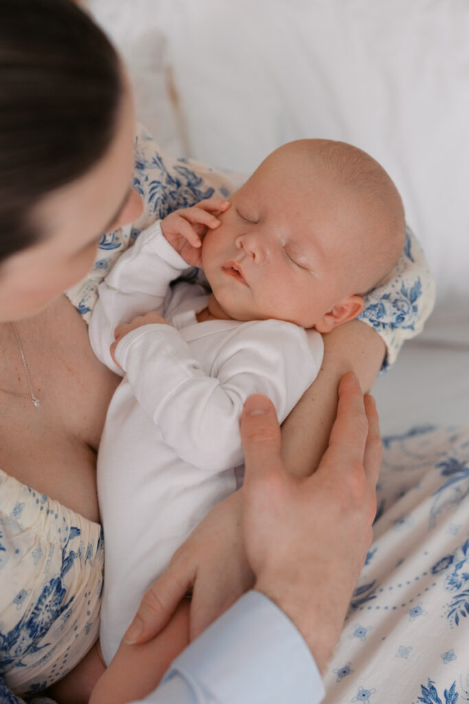 newborn baby boy sleeping in first time mom's arms during an in home newborn session in Rockridge, Oakland
