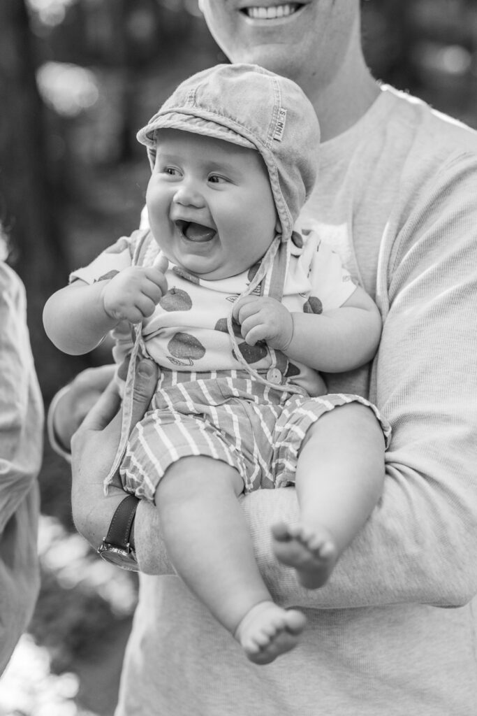 six month old baby laughs in dad's arms during Berkeley family photography session
