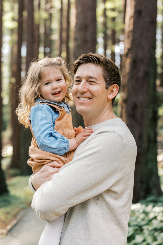 dad and two year old cuddle in the redwood grove at Berkeley Botanical Garden during Berkeley family photography session