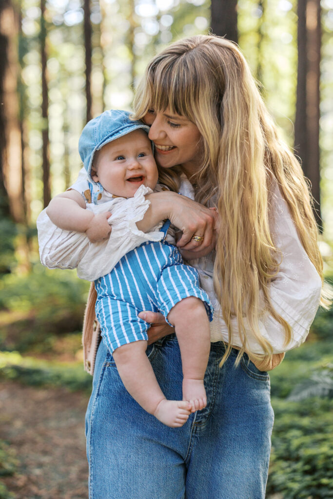 mom and baby boy snuggle in the redwood grove at Berkeley Botanical Garden
