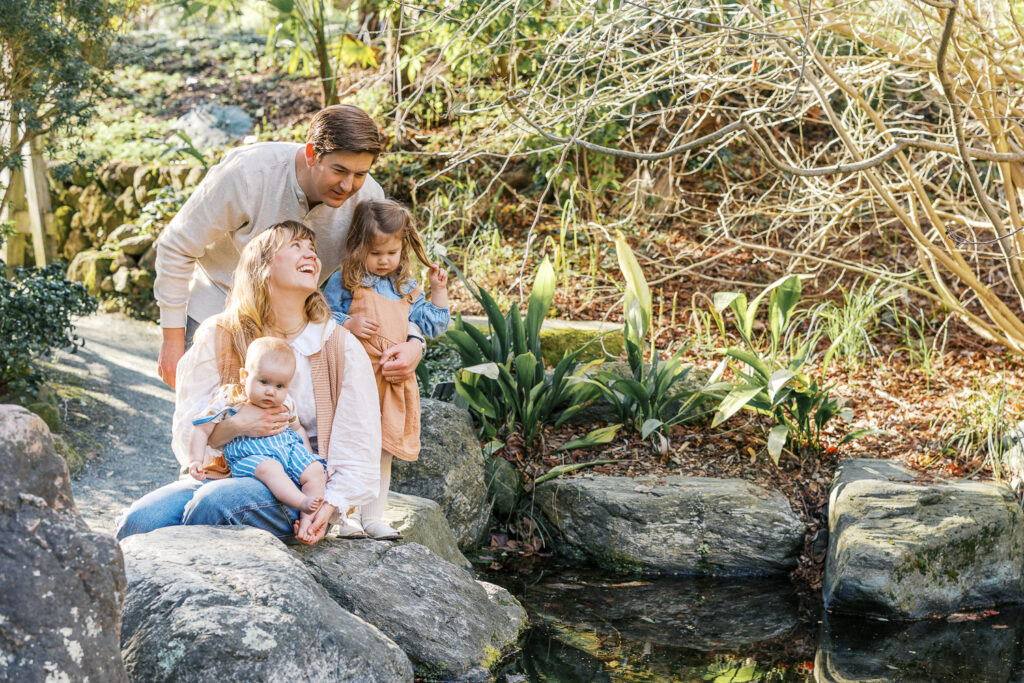 family of four look at the newts at the Japanese Pool during Berkeley family photography session