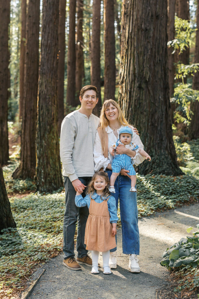 family of four poses in the redwood grove at Berkeley Botanical Garden during Berkeley family photography session