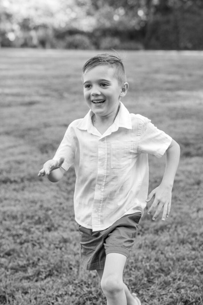 young boy runs on grass at Dracena Park