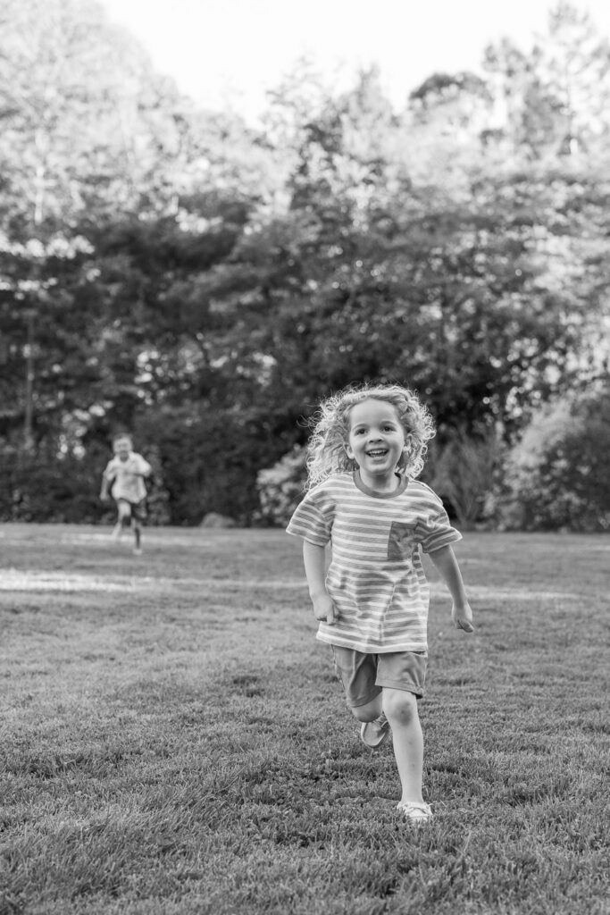 young boy runs on grass at Dracena Park
