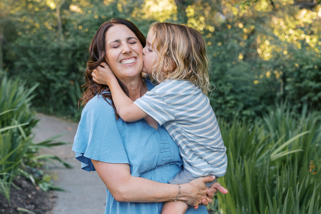 young boy kisses mom on the cheek during a piedmont family photography session at dracena park