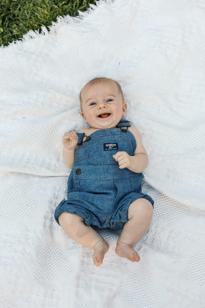 baby boy laughs while on a blanket at Dracena Park in Piedmont