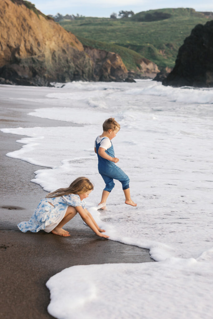 two young children play in ocean during bay area family photography session