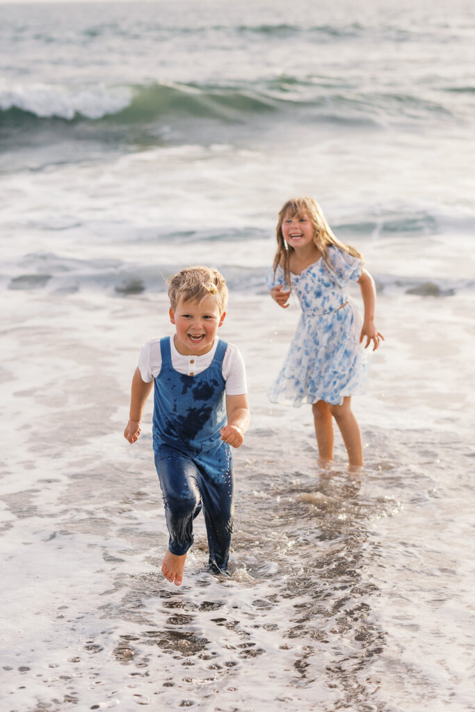 two young children play in ocean during bay area family photography session
