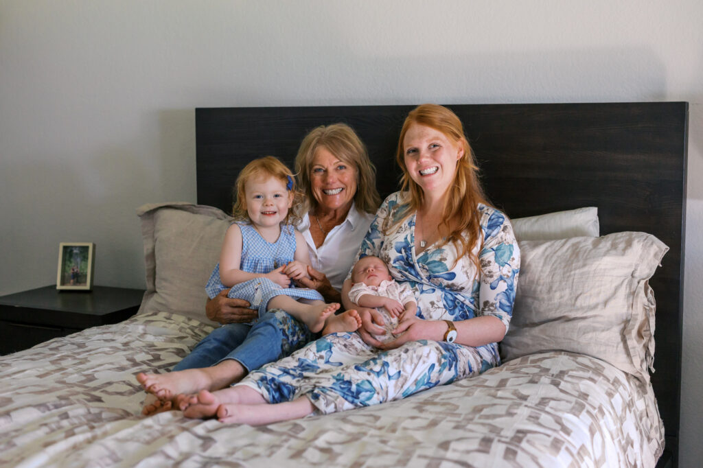 Grandma, mom, toddler and newborn smile during Alameda newborn photography session