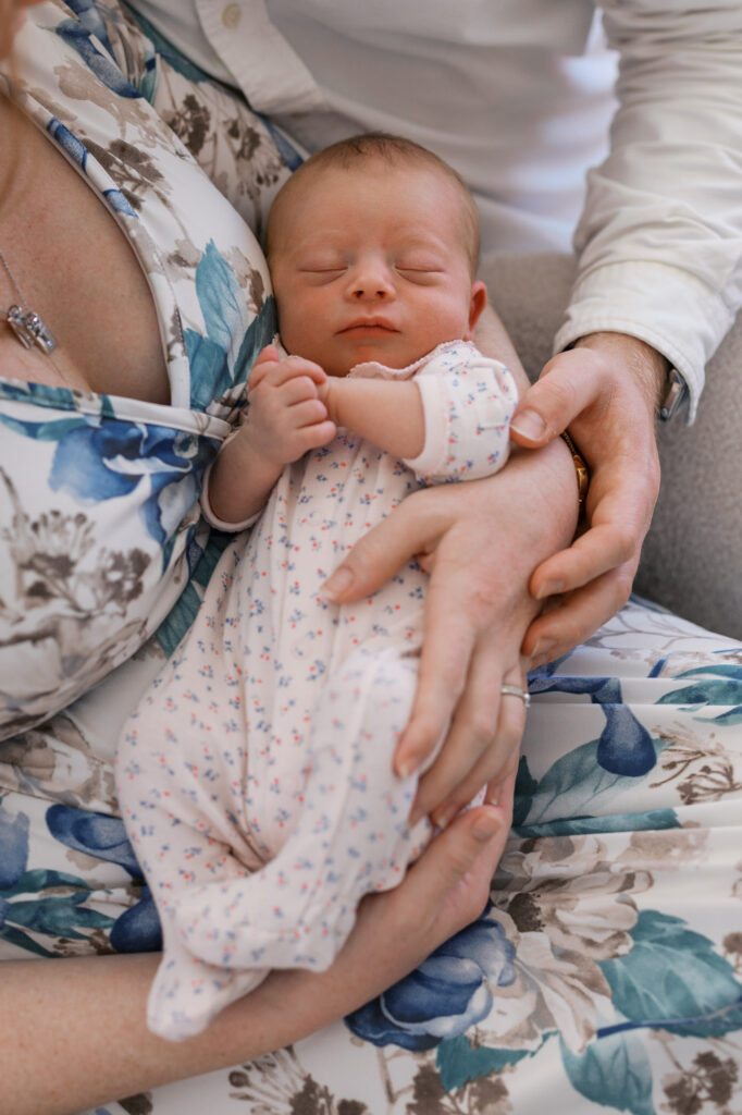 2 week old newborn girl being held in her parents arms during Alameda newborn photography session