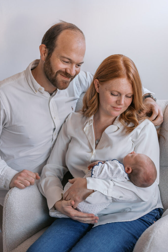 mom and dad hold newborn baby girl during in home Alameda newborn photography session