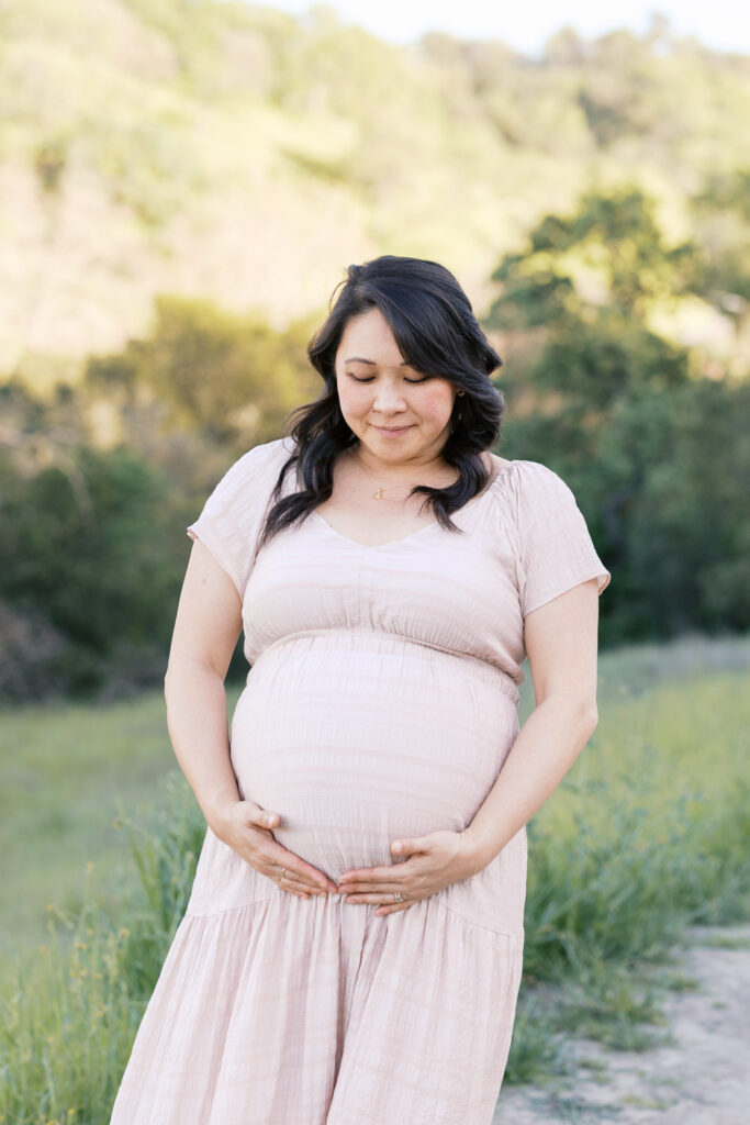 expecting mom gazes down at her baby bump during Walnut Creek maternity session