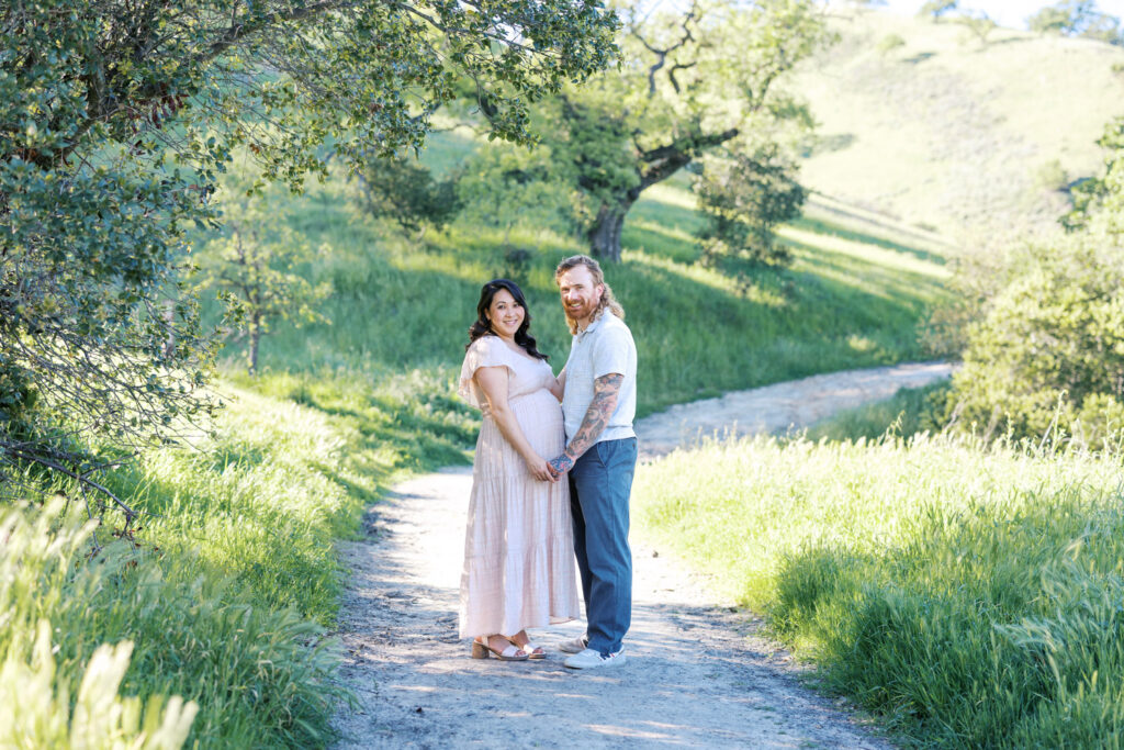 first time expecting parents pose for maternity photography session on a trail in Walnut Creek