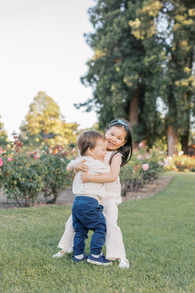 two young children embrace while laughing during San Jose Rose Garden photography session