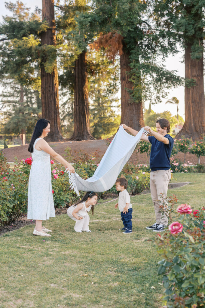 family of four plays in the rose garden during San Jose Rose Garden photography session