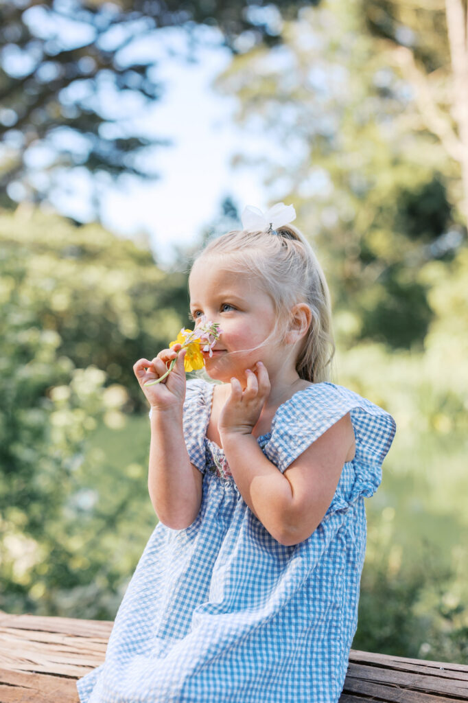 young girl smells the flower she found in Golden Gate Park