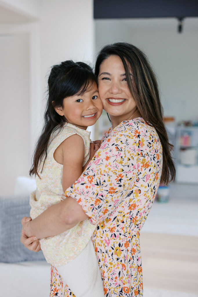 Mother and daughter hug and smile during San Mateo newborn photography session in home