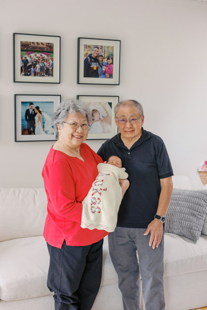 Grandparents hold and meet newborn baby boy for the first time during San Mateo newborn photography session