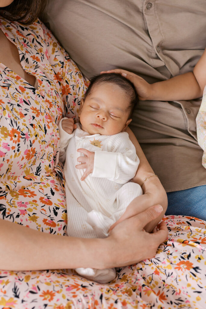 newborn baby boy captured at one month, in his family's arms, for his San Mateo newborn photography session