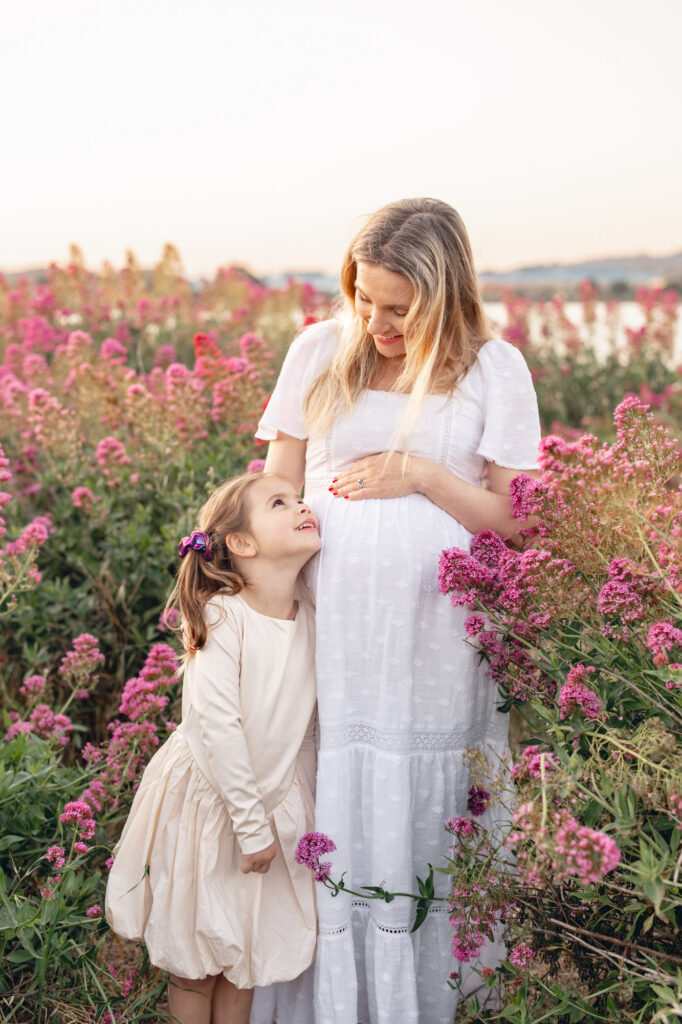 Oldest sister gazes up adoringly at her expecting mom during East Bay maternity session
