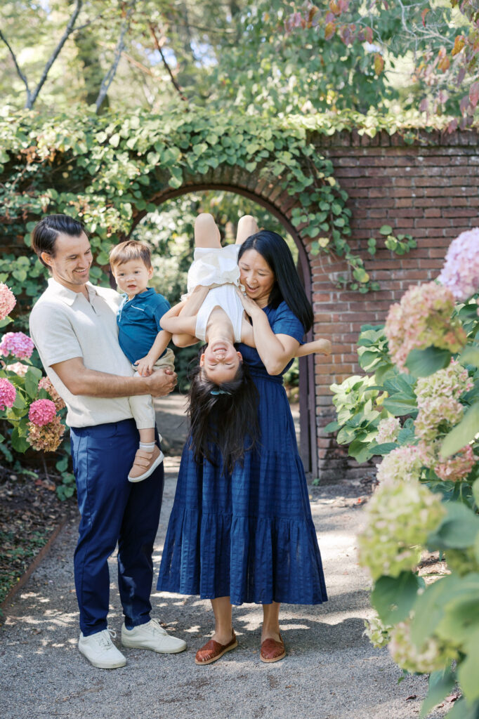 family of four plays in the hydrangeas during their summer Bay Area family photography session at Filoli