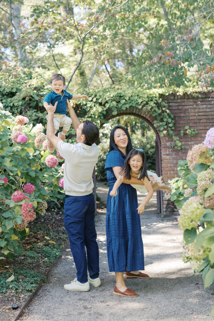family of four plays in the hydrangeas during their summer Bay Area family photography session at Filoli