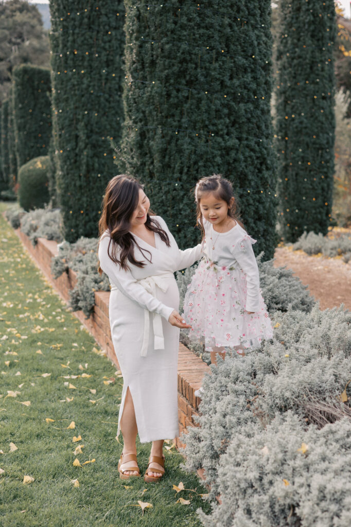 Young girl plays at Filoli during maternity photography session during holiday season