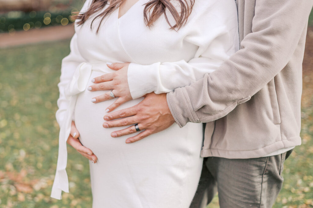 close up of expecting baby bump with couples hands at Filoli Gardens during their maternity session