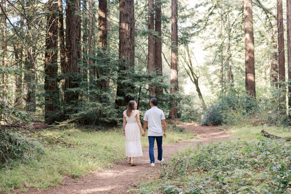 expecting couple walking through the Oakland redwoods during their Bay Area maternity session