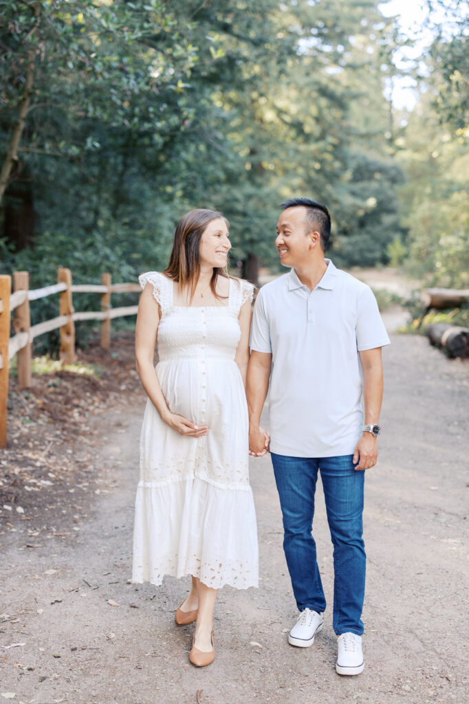 expecting couple walk through the Oakland redwoods during their East Bay maternity photography session