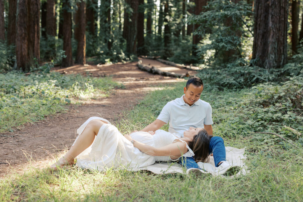 a couple lays in the Oakland redwoods