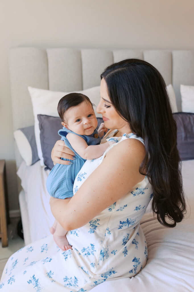 mom holds 2 month old newborn who looks at Dad off camera during Redwood City newborn session