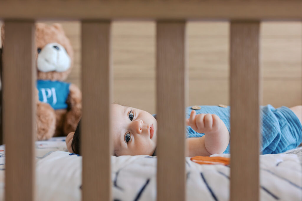 2 month old baby boy gazes out of his crib during Redwood City newborn session