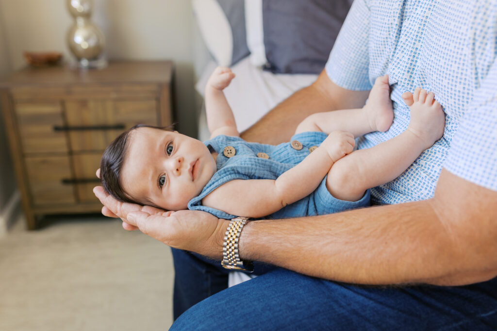 2 month old newborn looks at camera while in dad's arms during Redwood City newborn session