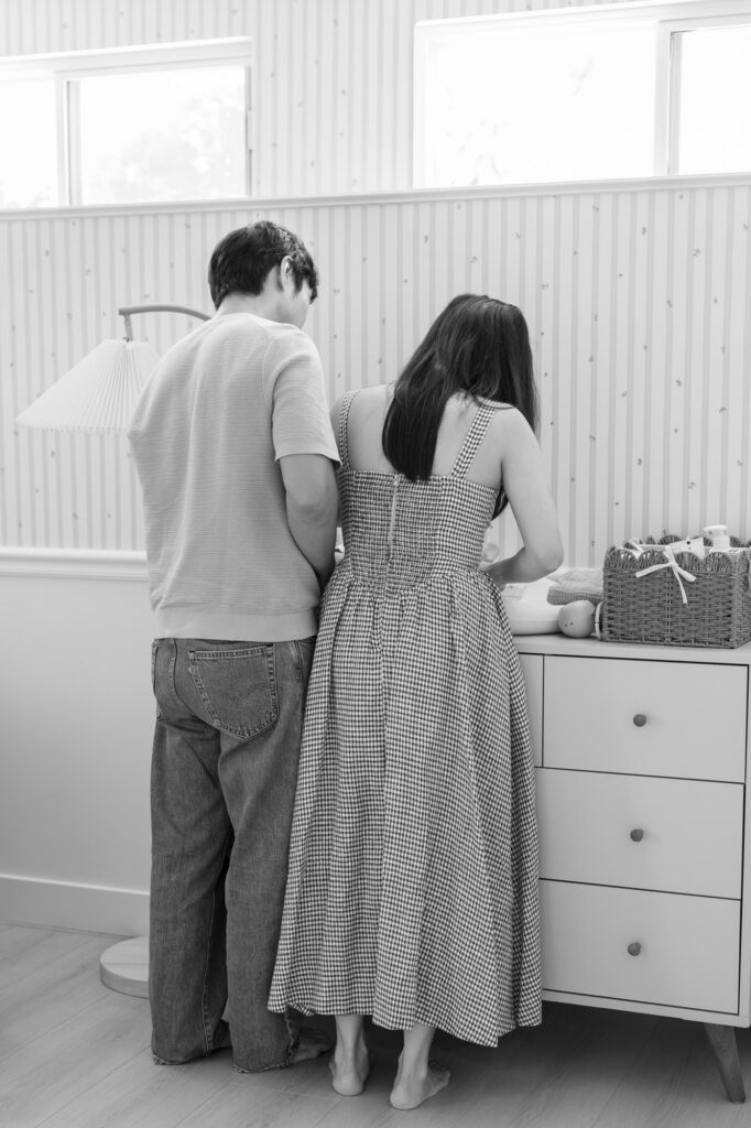 new parents change a newborn's diaper during their Santa Clara newborn photography session, black and white image