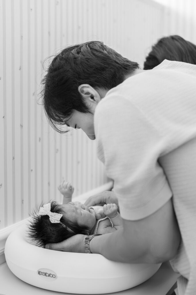 dad comforts newborn baby during a diaper change