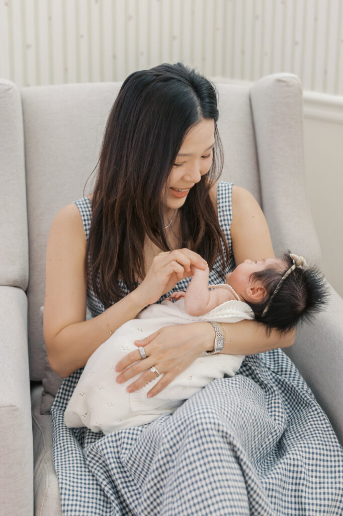 new mom gazes down and laughs at one month old baby girl during Santa Clara newborn photography session