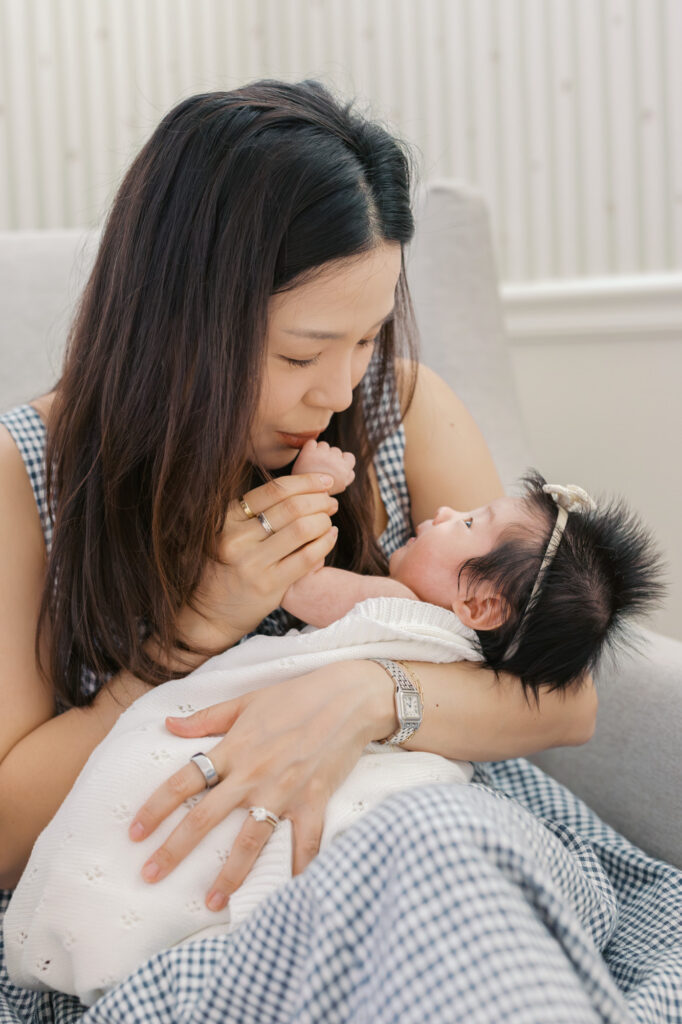 new mom kisses newborn baby's hand during Santa Clara photography session