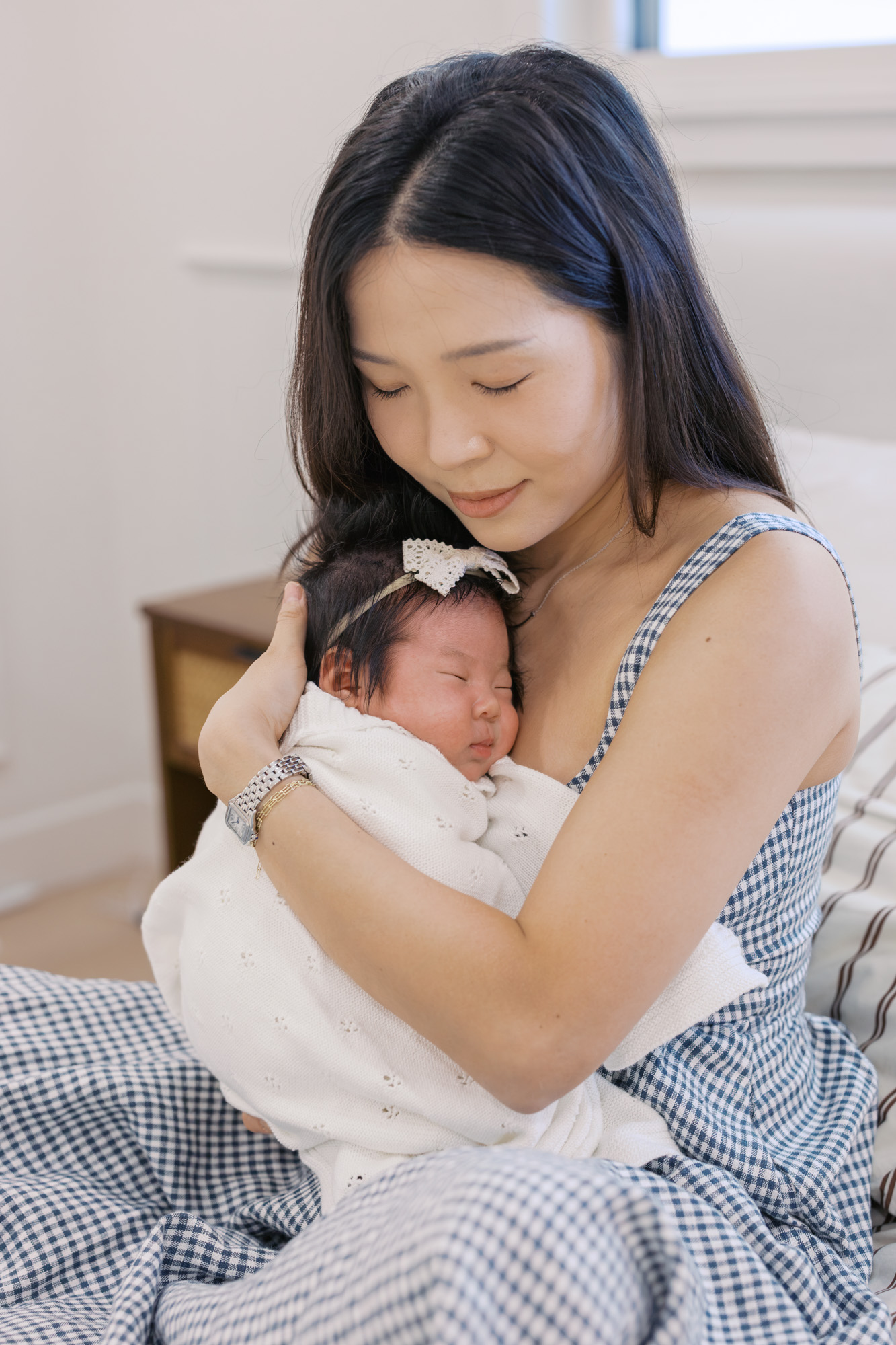 new mom holds sleeping baby girl to her chest during Santa Clara newborn photography session